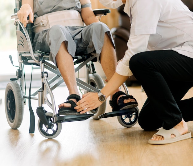 Médico o enfermero cuidador con un anciano en silla de ruedas con máscaras protectoras en casa o en un hogar de ancianos