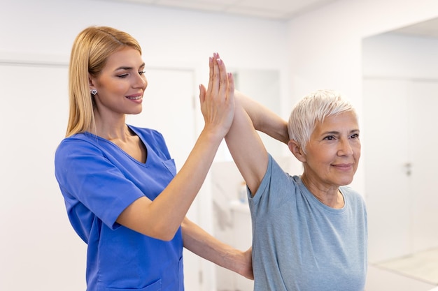 Médico o fisioterapeuta trabajando examinando el tratamiento del brazo lesionado de una paciente de edad avanzada estiramiento y ejercicio Hacer la terapia de rehabilitación del dolor en la clínica