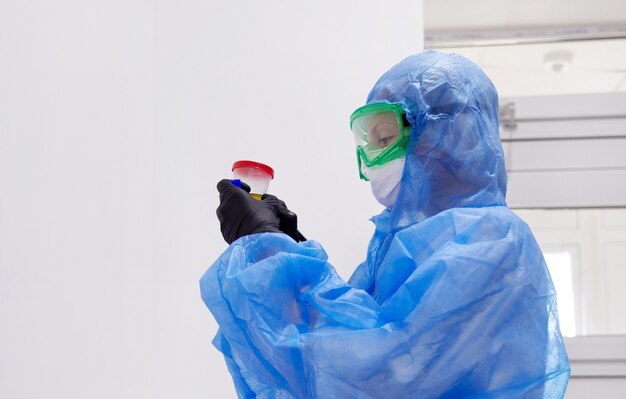 Médico o técnico mirando muestra de orina en botella preparada para examen de orina con microscopio