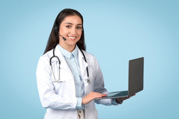 Médico oferecendo consulta on-line através de um portátil com fundo azul