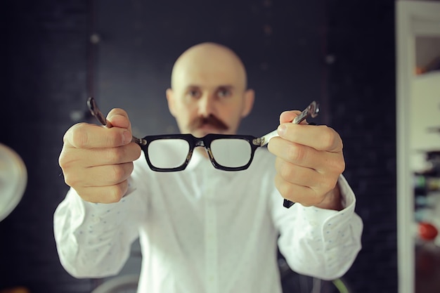 Foto el médico ofrece anteojos, concepto de medicina, vista, el hombre sostiene anteojos