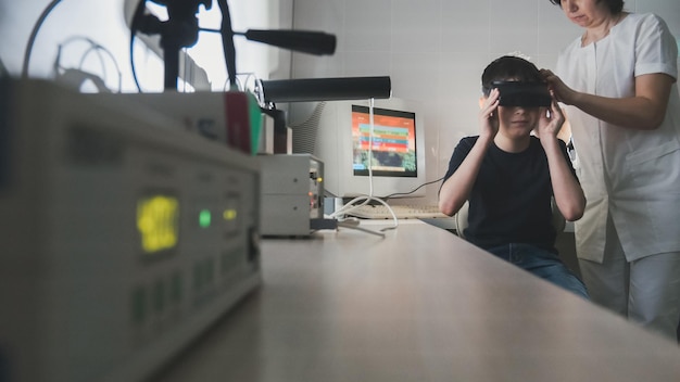 Médico oftalmologista verifica a visão da criança com a ajuda de óculos de realidade virtual estereovídeo grande angular