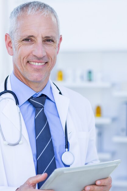 Médico olhando a câmera e segurando prancheta