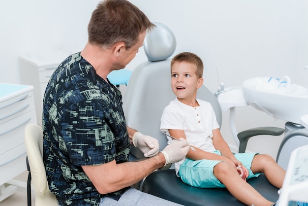 El médico ortodoncista le dice al niño cómo cuidar los dientes y mantener la higiene.