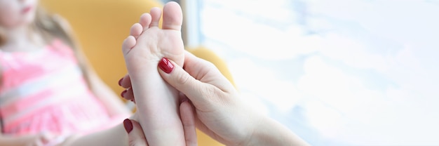 Médico ortopedista examinando los pies de la niña closeup