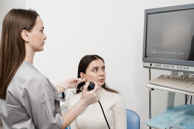 Médico otorrinolaringologista usando fibrolaringoscópio para examinar e tratar os ouvidos Otorrinolaringologista diagnostica e trata laringe e faringe, como rouquidão, nódulos nas cordas vocais, tumores, infecções e inflamações