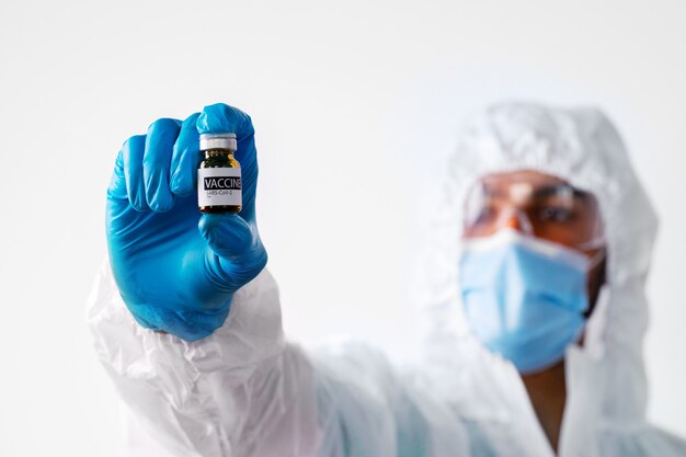 Foto médico ou enfermeiro com traje de proteção médico se preparando para a vacinação