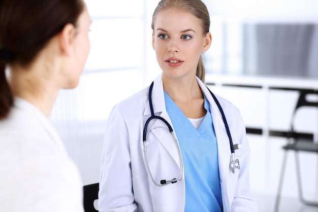 Médico y paciente durante la consulta Médico en el trabajo llenando el registro del historial de medicamentos mientras está sentado en una sesión de retratos en el hospital de emergencia Concepto de medicina y atención médica