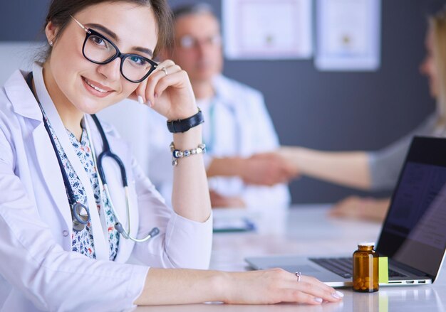 Médico y paciente discutiendo algo mientras están sentados en la mesa Concepto de medicina y atención médica