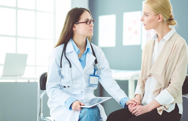 Médico y paciente discutiendo algo mientras están sentados en la mesa Concepto de medicina y atención médica