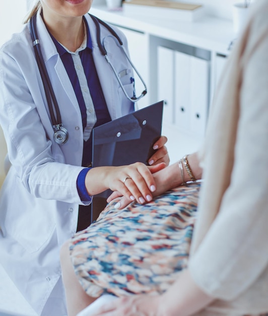 Médico y paciente discutiendo algo mientras están sentados en la mesa. Concepto de medicina y atención de la salud.