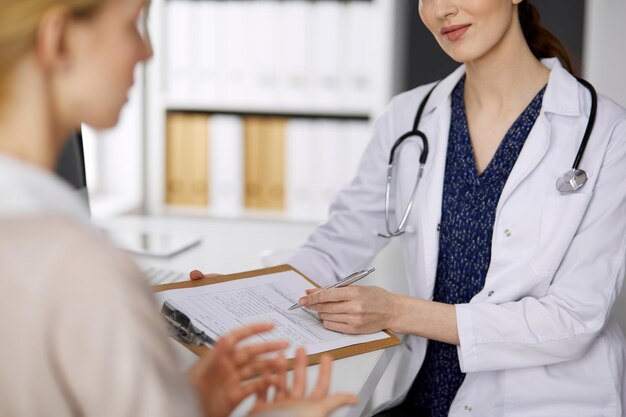 Médico y paciente discutiendo el examen de salud actual mientras están sentados en la clínica. Perfecto servicio médico en el hospital. concepto de medicina.