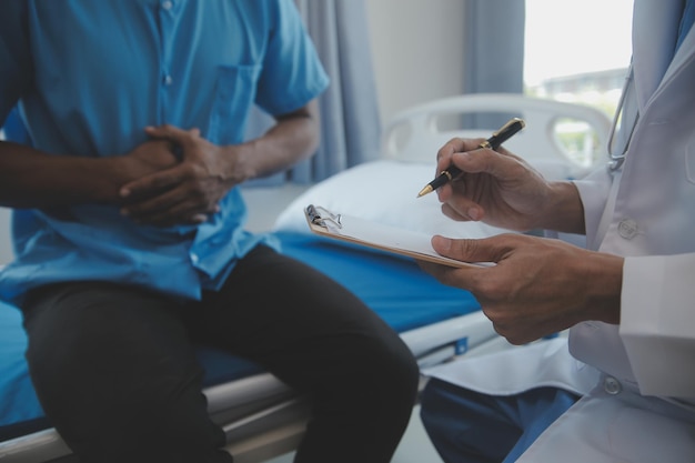 Foto médico y paciente discutiendo el examen de salud actual mientras están sentados en el escritorio en el primer plano de la oficina de la clínica concepto de medicina