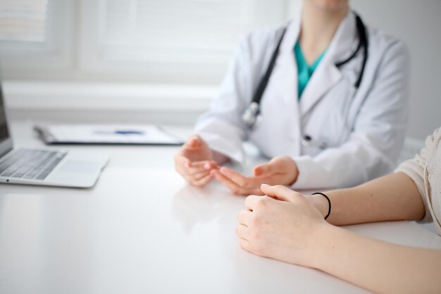 El médico y el paciente están discutiendo algo solo con las manos en la mesa