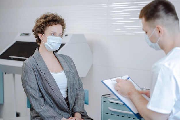 Un médico y un paciente hablan entre ellos.