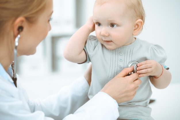 Médico y paciente en el hospital. La niña está siendo examinada por un médico con estetoscopio. Concepto de medicina.