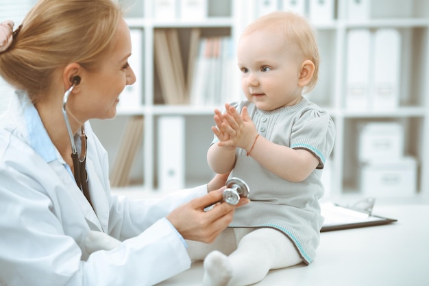 Médico y paciente en el hospital. La niña está siendo examinada por un médico con estetoscopio. Concepto de medicina.