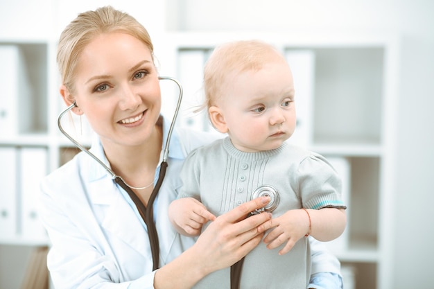 Médico y paciente en el hospital. La niña está siendo examinada por un médico con estetoscopio. Concepto de medicina.