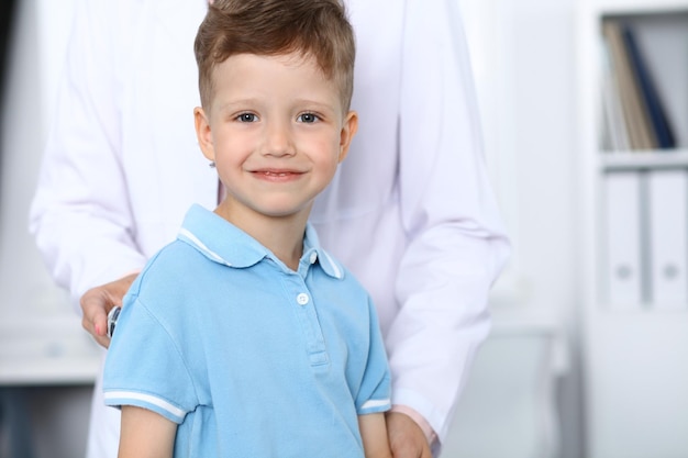 Médico y paciente en el hospital Niño feliz divirtiéndose mientras lo examinan con estetoscopio Concepto de atención médica y seguro