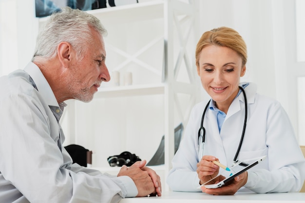 Foto médico y paciente mirando tableta