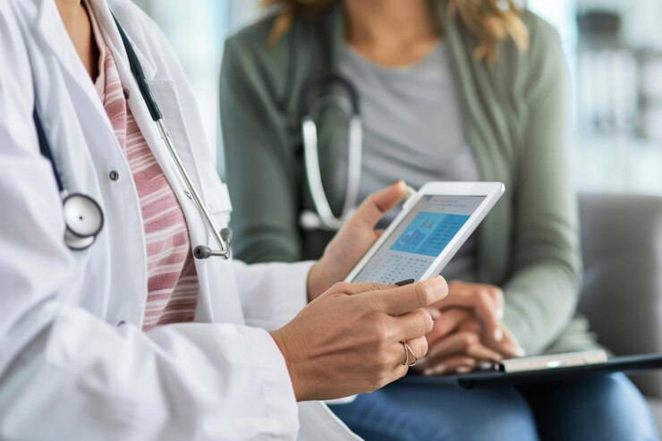 Médico y paciente revisando información médica en una tableta en un entorno clínico