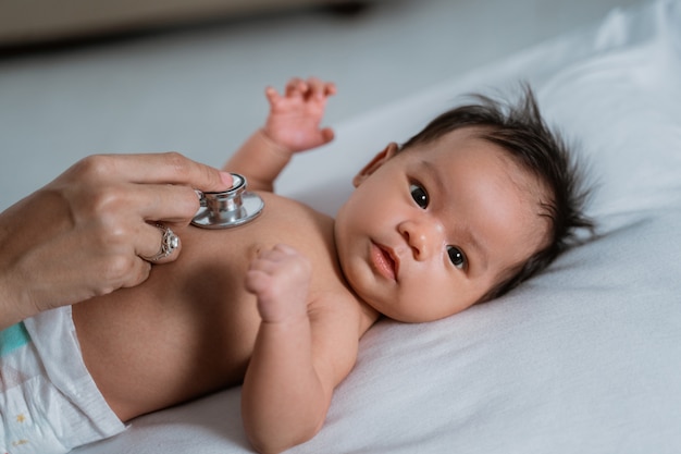 Médico pediatra examinando niña