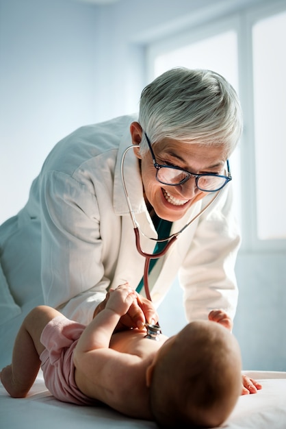 Médico pediatra feliz examina o bebê. cuidados de saúde, pessoas, conceito de exame