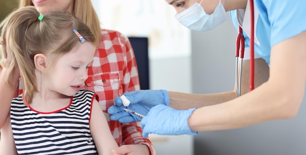 Médico pediatra inocula menina no ombro