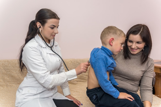 Médico pediatra niño escuchando respiración con estetoscopio