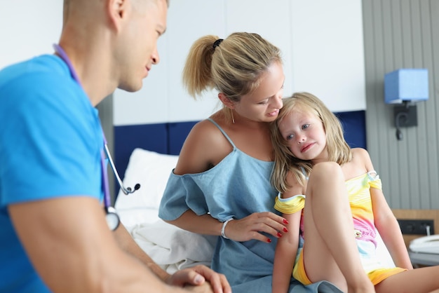 Médico pediatra realiza consulta médica mamá con niño asustado comunicación de