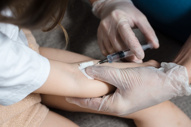 Médico pediatra vacunando a un niño pequeño