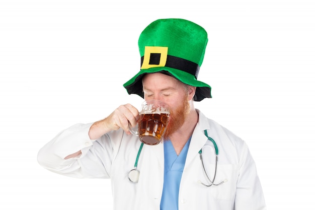 Médico pelirrojo con sombrero verde bebiendo una cerveza
