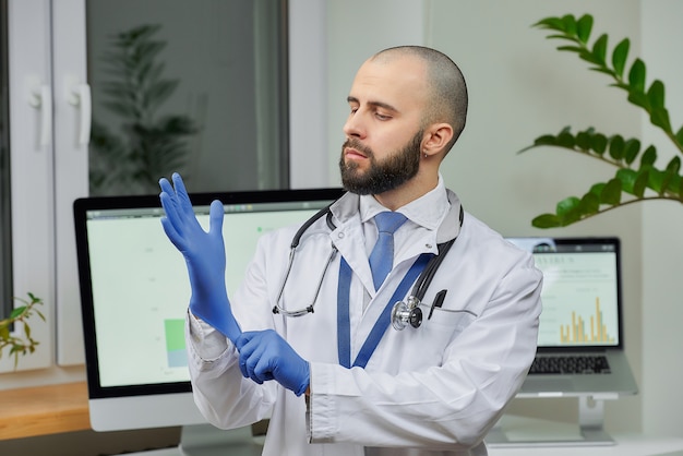 Un médico poniéndose un guante médico desechable