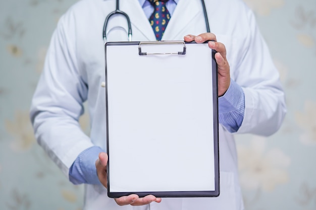 Médico con portapapeles en blanco para diagnóstico de nota de pacientes en el hospital.