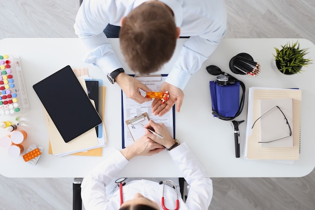 Médico prescreve receita para paciente para medicamento vista de cima prescrever ajuda de medicamentos vitamínicos