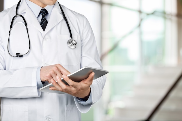 Médico de primer plano en el hospital trabajando con tablet pc