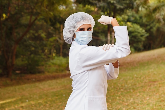 Médico de primera línea que hace el símbolo del empoderamiento femenino o la militancia