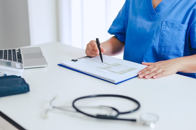 Médico profesional en bata de uniforme blanco entrevista al paciente consultor.