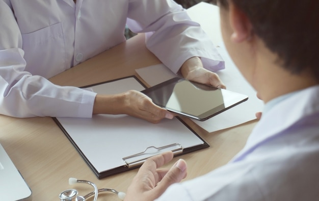 Médico profesional en la entrevista de uniforme blanco vestido de bata.