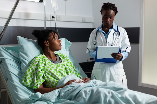 Médico profissional falando com paciente afro