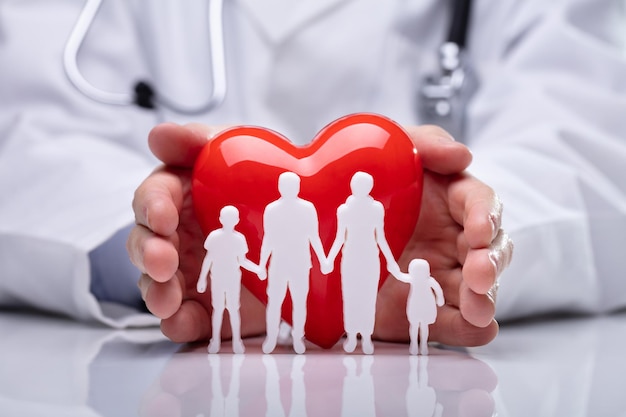 Médico protegiendo a la familia recortada y en forma de corazón