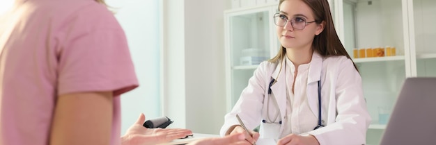 Médico que se comunica con una paciente femenina en la clínica y escucha sus quejas profesional