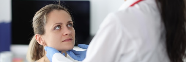 Foto médico que examina los ganglios linfáticos submandibulares de los pacientes en la clínica