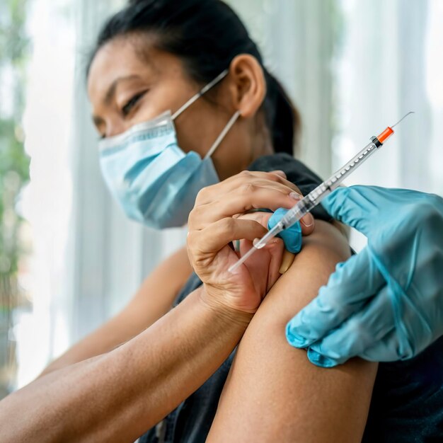 Médico que faz vacinação por injecção ao paciente para prevenir a pandemia da doença gripe ou vírus da gripe