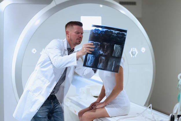 Médico que muestra al paciente una resonancia magnética de la columna vertebral en la clínica métodos modernos de examen y diagnóstico