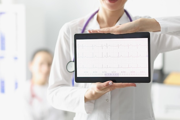 Médico que muestra la pantalla de la tableta digital con resultado de cardiograma de corazón