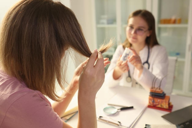 Médico que ofrece medicamentos para las puntas abiertas a una paciente en una clínica de productos farmacológicos para