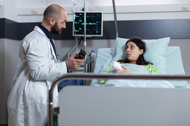 Foto médico que presenta un analgésico recetado alternativo sobre la recuperación de la elección de los pacientes en la sala privada del hospital. mujer después de una intervención quirúrgica escuchando la sugerencia de tratamiento médico.