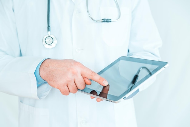 Médico que trabalha em um tablet digital