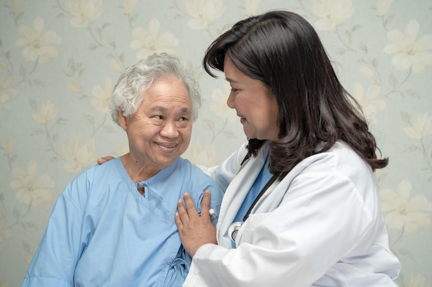 Médico que usa estetoscopio para verificar que el paciente se siente en una cama en la sala del hospital concepto médico fuerte y saludable